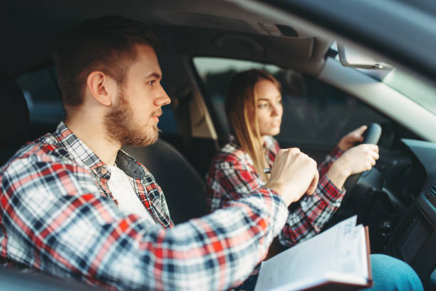 istock Male instructor and female student, driving lesson 1009427412