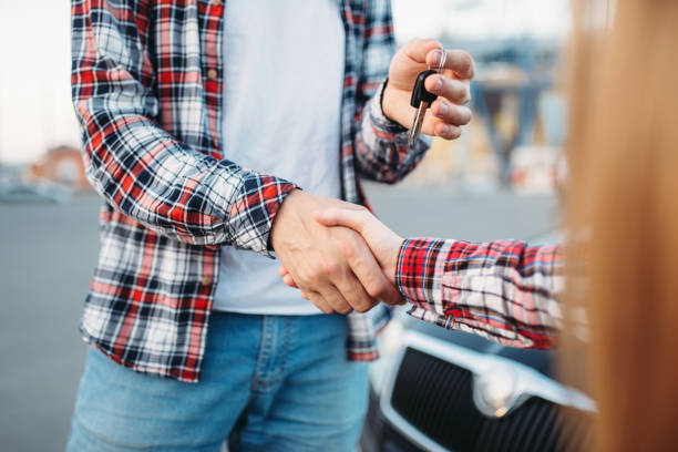 istock Driving instructor gives car key to female student 1009427456