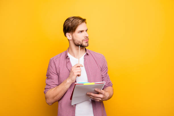 istock Decide think dream dreamy imagine analyze people brainstorm person concept. Portrait of pensive thoughtful handsome smart clever focused guy with copybook pen in hands isolated on bright background 1009430534