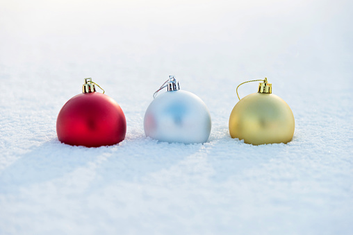 Three Christmas balls on the snow.