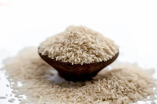 Photo of Indian special most popular uncooked Basmati long grained with a unique aroma in a clay bowl isolated on white.