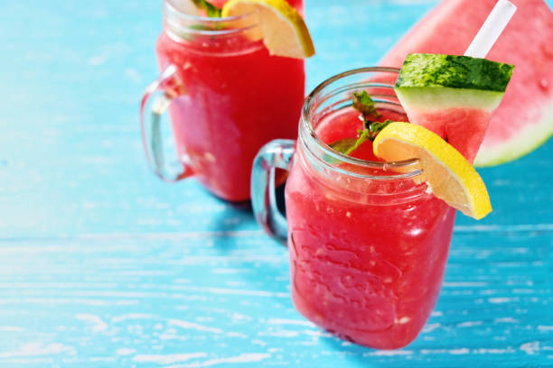 istock Watermelon summer cocktail with ice and mint leaves. Cold refreshment drink on pastel blue wooden background. 1009461582