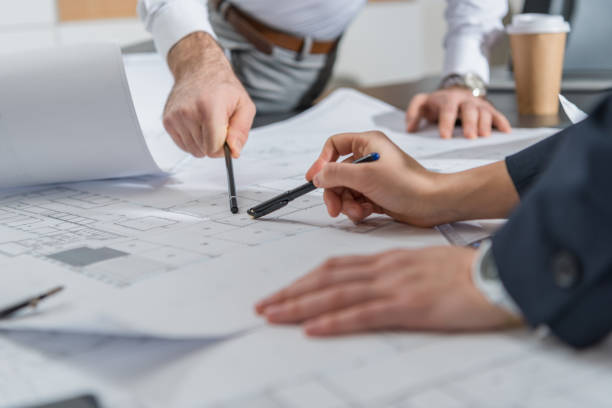 istock cropped shot of architects working with building plans together at office 1009465330