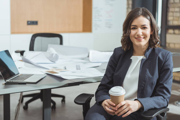 istock beautiful young architect with coffee to go in front of workplace 1009467592