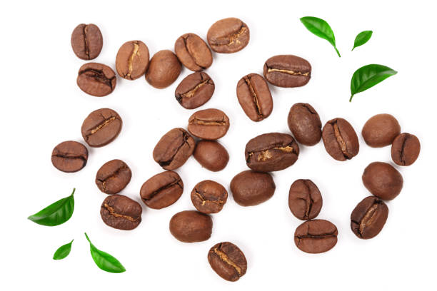 istock Coffee beans decorated with green leaves isolated on white background. Top view 1009468050