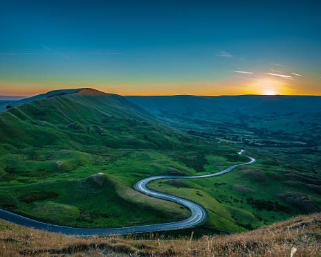 The winding road towards Barber Booth in the Peak District at Sunset viewed from Mam Tor.