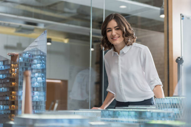 istock beautiful young architect standing near building models 1009474100