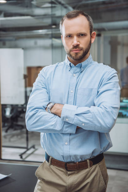 istock handsome successful businessman with crossed arms at office 1009474522