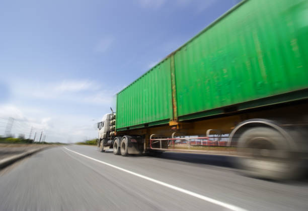 istock Truck on highway road with big container, 1009486744