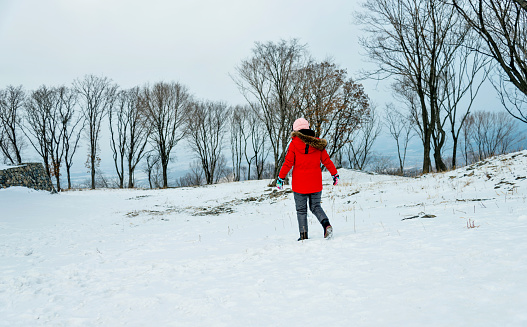 Woman walking in snowy forest.