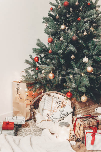 istock beautiful traditional christmas tree with lights, space for text. gifts and presents under tree with ornaments in festive room. happy holidays. merry christmas and happy new year concept 1009493800