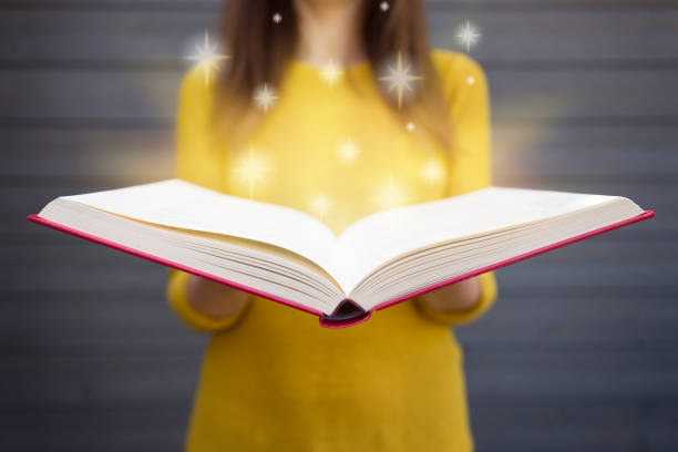 Light coming from book in woman's hands. Concept of wisdom, religion, reading, imagination, knowledge Light coming from book in woman's hands. Concept of wisdom, religion, reading, imagination, knowledge encyclopaedia stock pictures, royalty-free photos & images