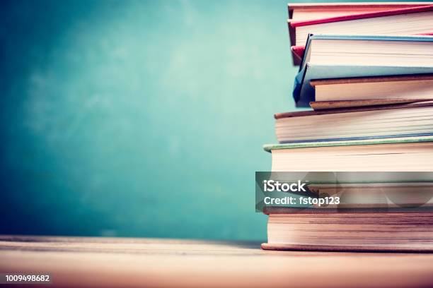 Textbooks On Wooden School Desk With Chalkboard Stock Photo - Download Image Now - Book, University, Stack