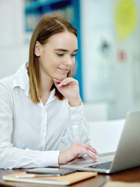istock Smiling young woman browsing on laptop 1009514640