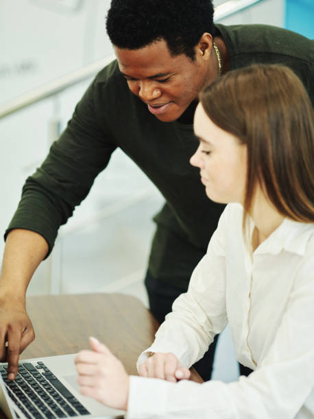 istock Black male explaining woman how working on laptop 1009517854