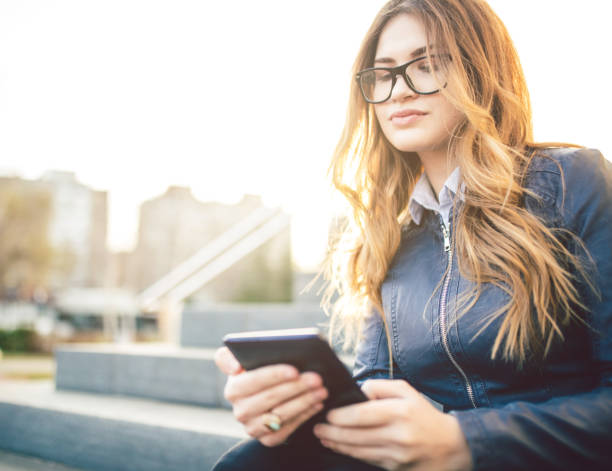 istock Girl sitting on the steps outdoor and using tablet. 1009524110