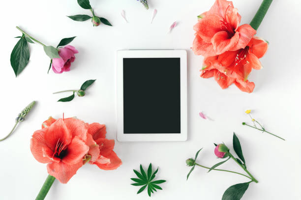 istock Flat lay white tablet with blank desktop screen and flowers 1009538914