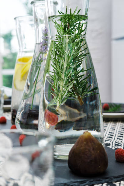 istock Water in glass decanters with oregano and served table 1009541614