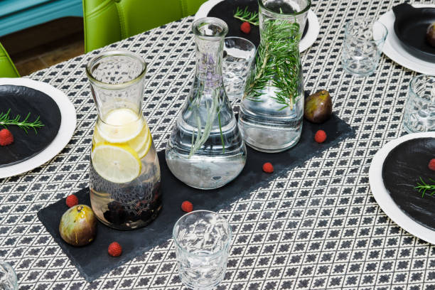 Water in glass decanters with oregano and served table