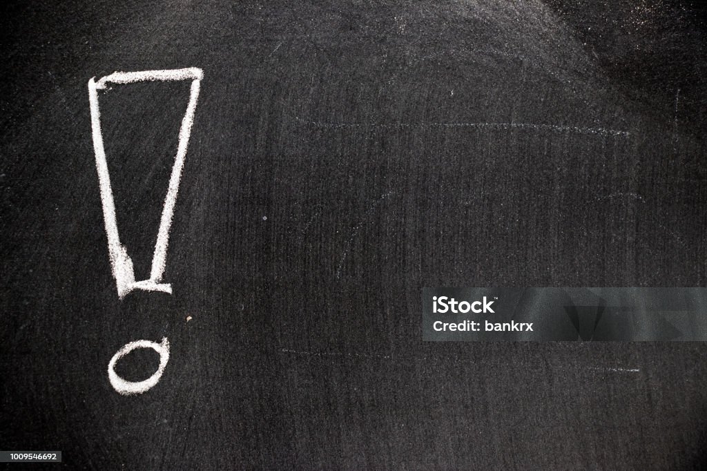 White color chalk hand drawing in exclamation mark with blank space shape on blackboard background Exclamation Point Stock Photo