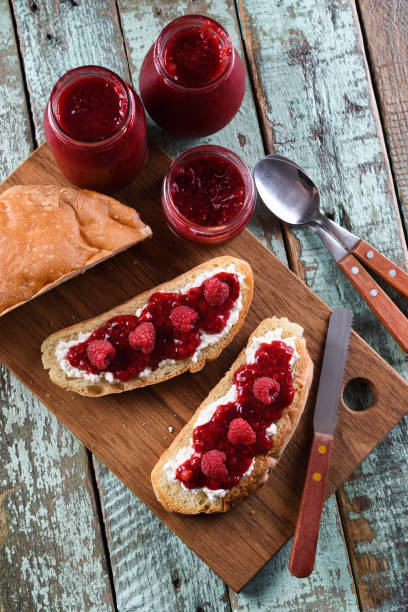 istock Healthy snack. Raspberry jam, ricotta and raw berries on ciabatta bread on blue background 1009547188