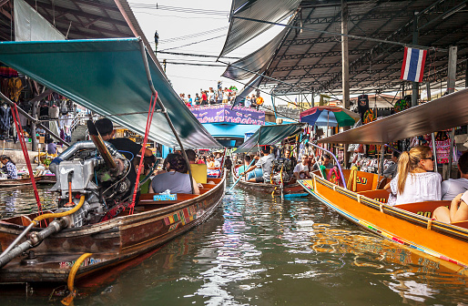 Damnoen Saduak (Thailand) - 7 June 2017: Lots of tourists are visiting the famous Damnoen Saduak Floating Market, the most popular floating market in Thailand