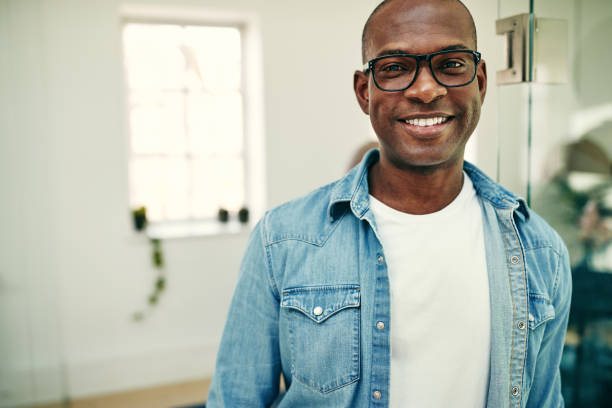 istock Smiling African businessman standing in a modern office 1009561694