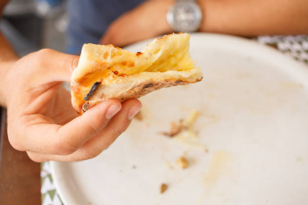 istock Young man holding bitten slice of pizza , Trieste , Italy. 1009565548