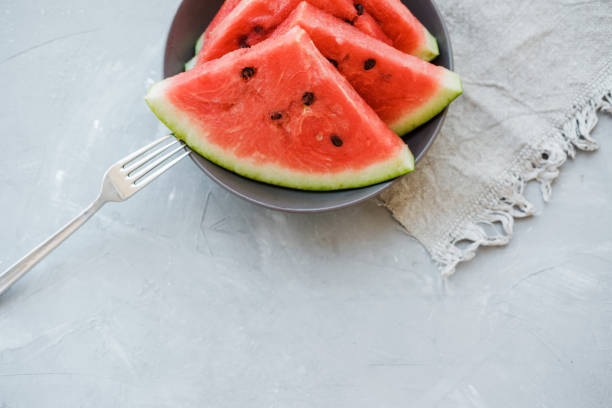 istock Watermelon slices on a plate in summertime on a gray background. Copy space 1009573990