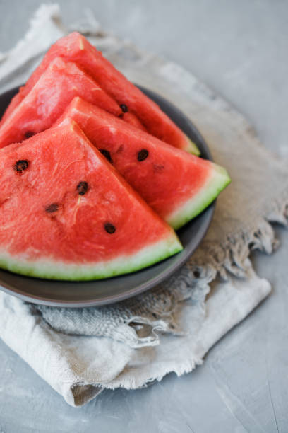 istock Watermelon slices on a plate in summertime on a gray background 1009574454