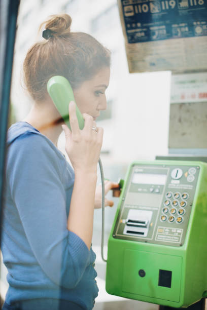 日本の電話ブースを使用して美しい白人女性 - pay phone ストックフォトと画像