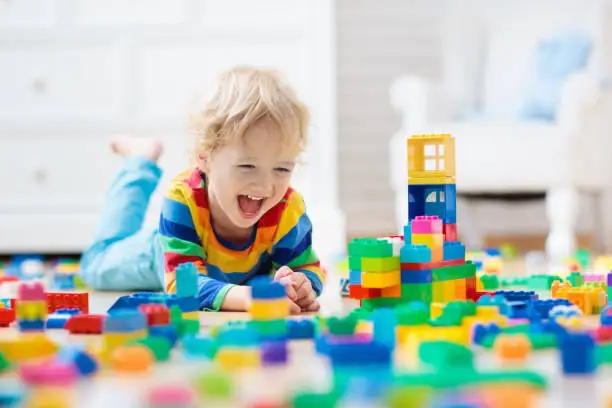 Photo of Child playing with toy blocks. Toys for kids.