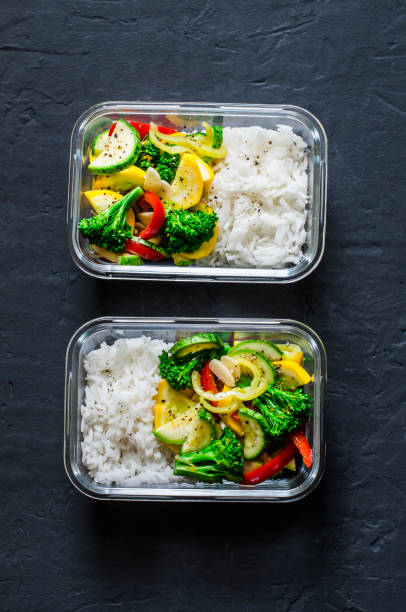 istock Vegetarian lunch box - stewed vegetables and rice on a dark background, top view. Health food concept 1009600708