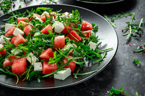 Fresh Juicy Watermelon arugula Feta salad with mint and orange, lemon dressing. summer dish. healthy food Fresh Juicy Watermelon arugula Feta salad with mint and orange, lemon dressing. summer dish. healthy food. rucola stock pictures, royalty-free photos & images