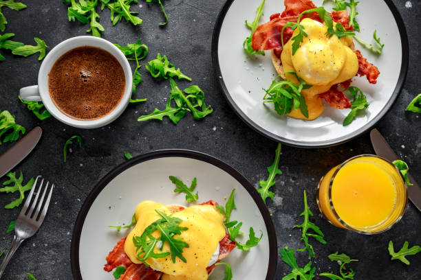 istock Eggs Benedict on english muffin with crispy bacon, wild rocket salad and hollandaise sauce 1009603586
