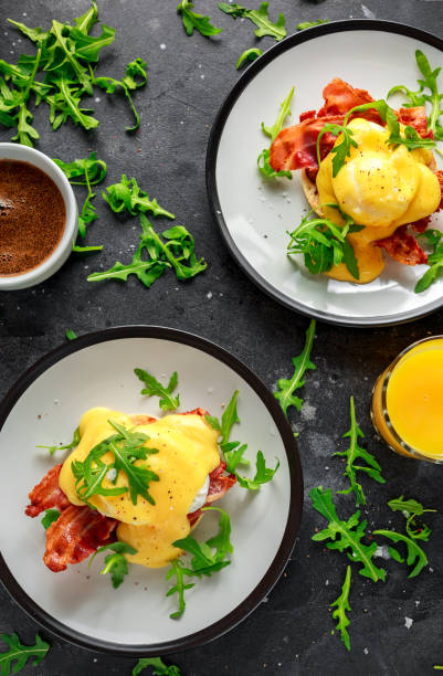 istock Eggs Benedict on english muffin with crispy bacon, wild rocket salad and hollandaise sauce 1009603596