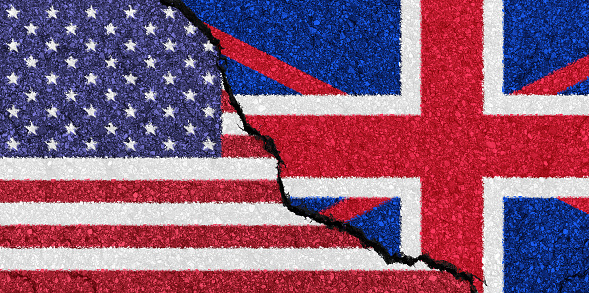 USA and UK flags painted on a cracked wall symbolizing difficult diplomatic relations between the UK and USA