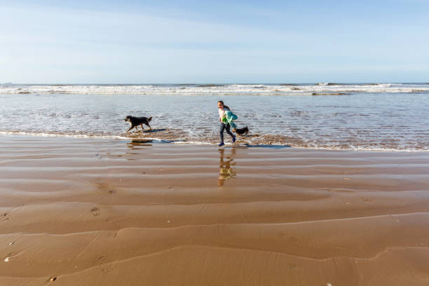 istock Nine year old girl playing with her dog 1009629114