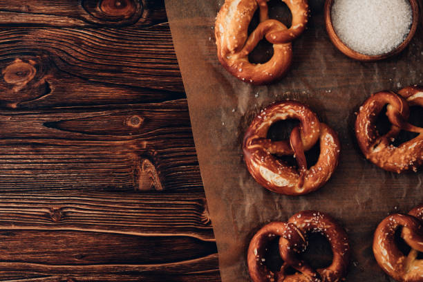 pretzel salado alemán tradicional de la lejía con la sal en papel de pergamino. poster banner para panadería. imagen de space.top view.toned de copia. - pretzel german culture food salt fotografías e imágenes de stock