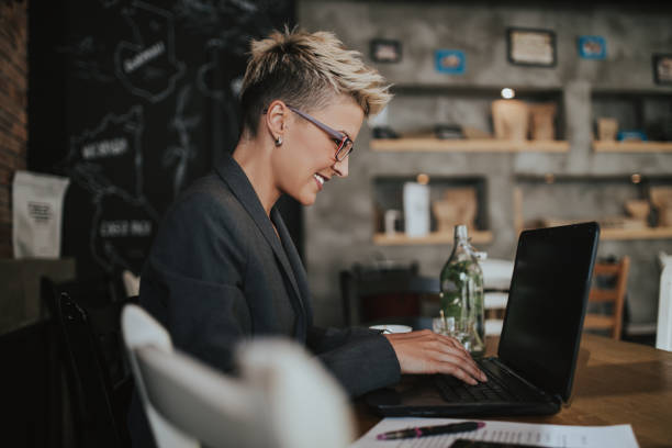 Young positive woman with glasses working in modern office.
