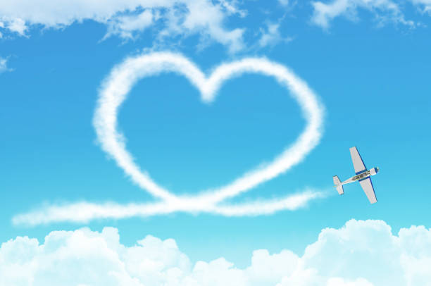Love figurative heart from a white smoke trail light-engine airplane among the clouds. Love figurative heart from a white smoke trail light-engine airplane among the clouds aerobatics photos stock pictures, royalty-free photos & images