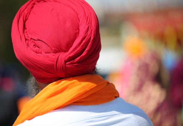sihk man with red turban during the religious rite