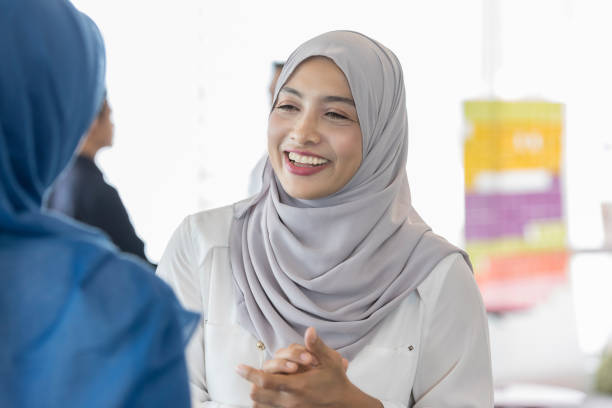 istock Malaysian woman enjoys conversation with coworker 1009647108