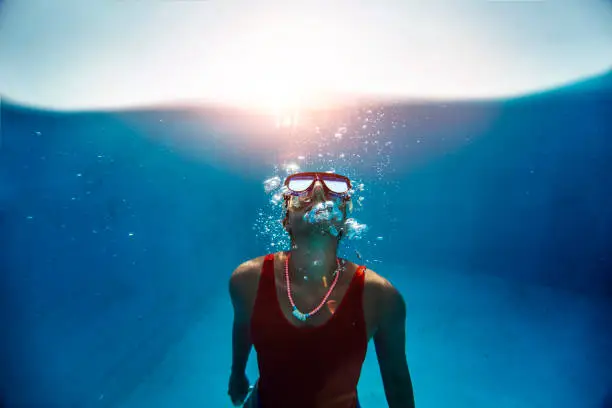 Underwater view of a young woman snorkeling on a sunny summer day