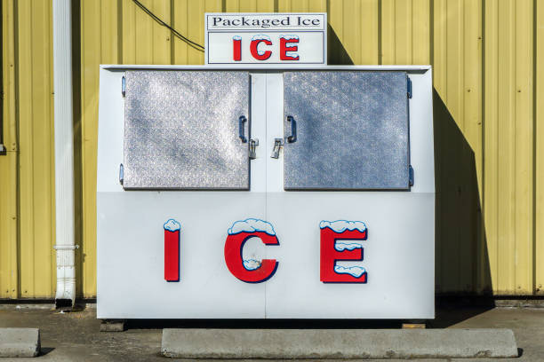 Outdoor Ice Freezer Packaged Ice freezer machine against a yellow wall during a hot and sunny day of summer outside a grocery store, Oregon, USA. ice machines stock pictures, royalty-free photos & images