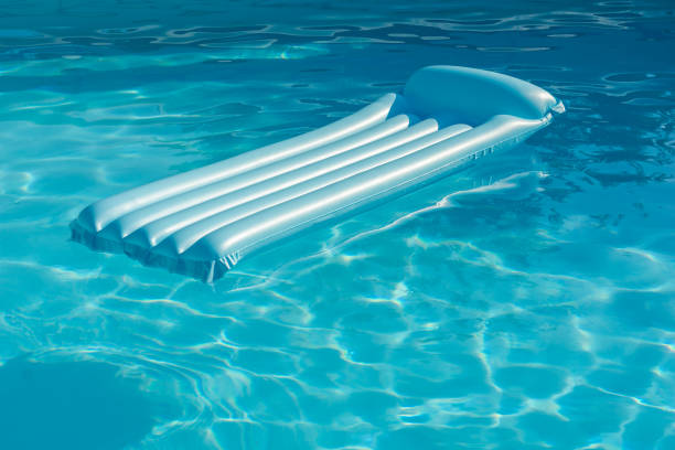 Blue inflatable mattress floating on a swimming pool. Summer and holidays concept.