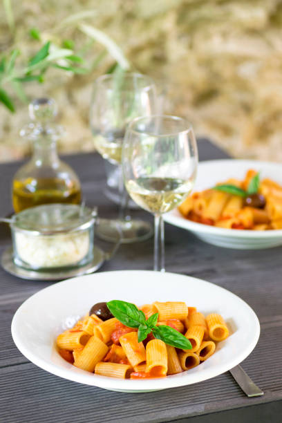istock Italian pasta with tomatoes and basil and white wine in authentic interior 1009661598