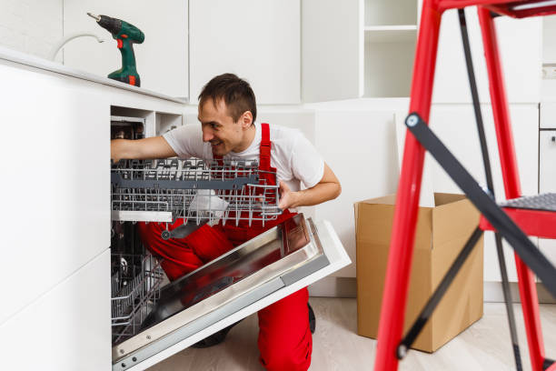 istock Repairman examining dishwasher with toolbox in kitchen 1009672184