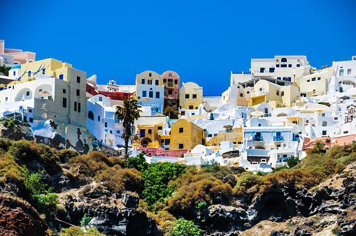 Colorful guesthouses and apartments overlook the caldera in Oia on Santorini Island, Greece