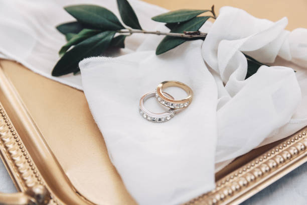 istock Wedding rings on gold tray with olive branch 1009680466